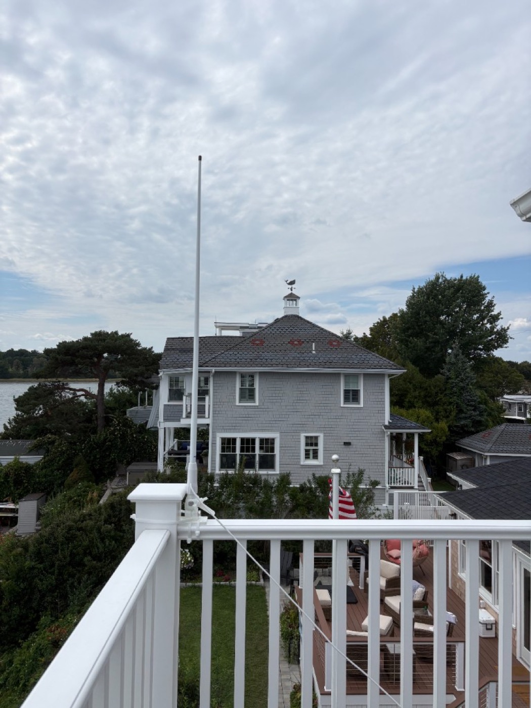 Marine VHF antenna mounted on a deck railing overlooking the harbor