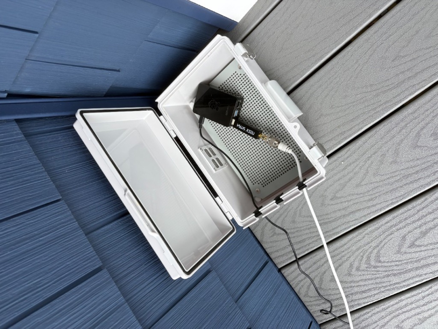 The enclosure mounted on an outside wall, antenna cable attached